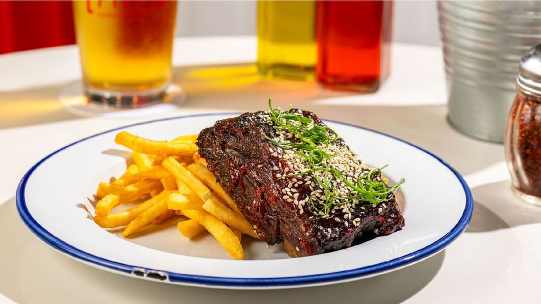 Hearty plate of glazed meat topped with sesame seeds and crispy french fries at Sunway Lagoon Hotel