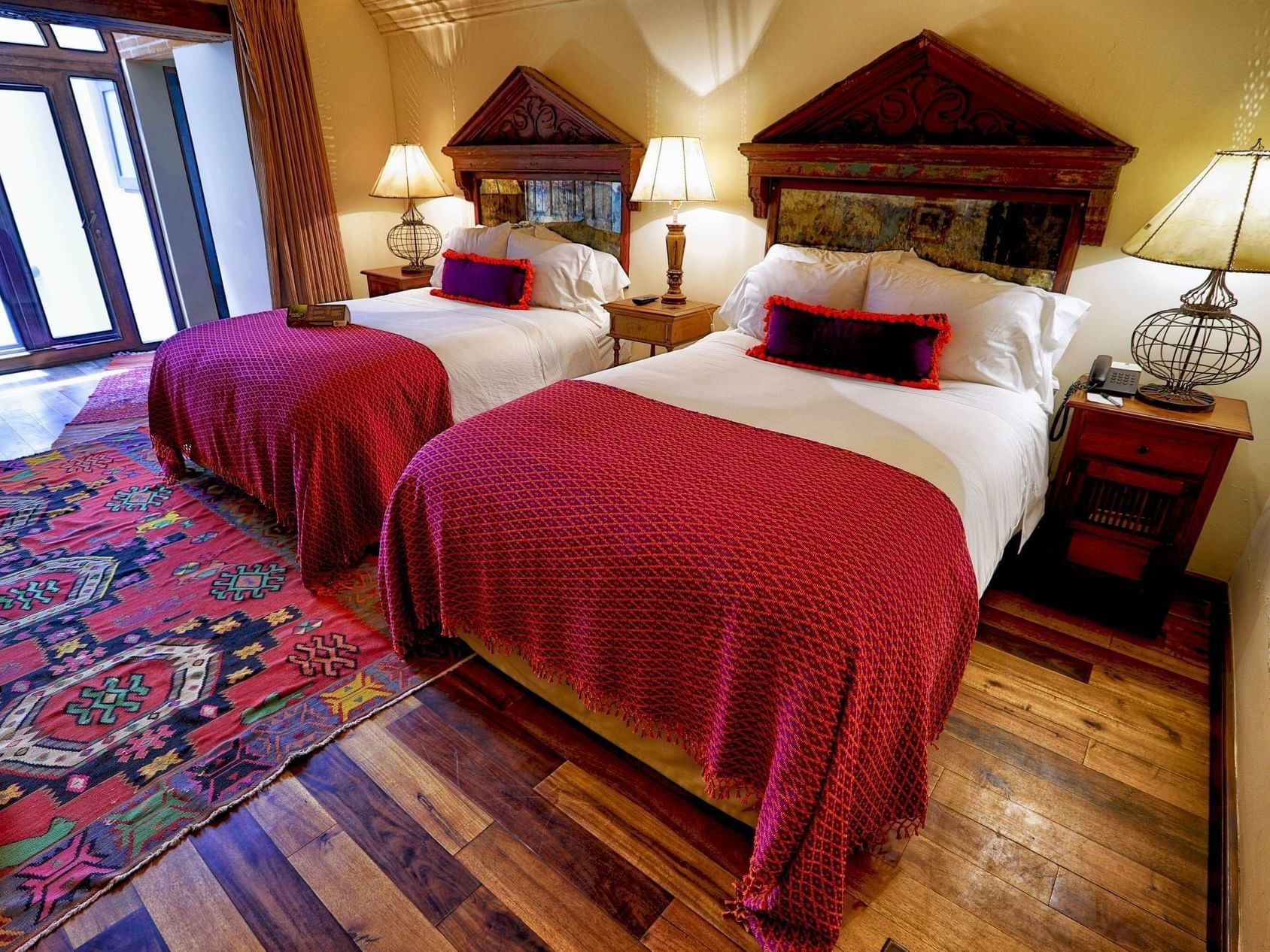 Beds with cushioned headboard & wooden floors in Deluxe 2 Double at Pensativo House Hotel