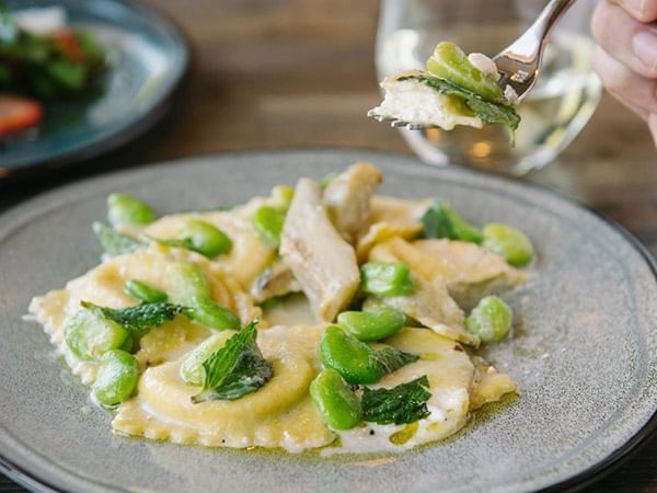 Plate of gourmet ravioli with green beans and herbs served in Apropos Restaurant & Bar at The Abbey Inn & Spa