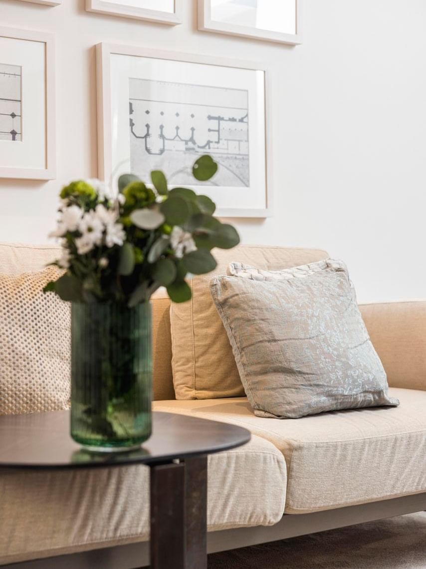 A vase of white flowers adorns a table beside a comfortable couch at Margutta 19