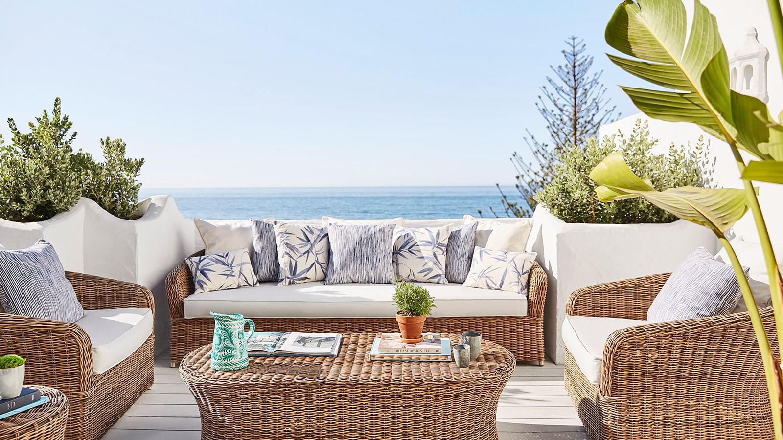 Imperial Beach Suite outdoor terrace with wicker furniture, pillows, and a view of the Sea from the Marbella Club