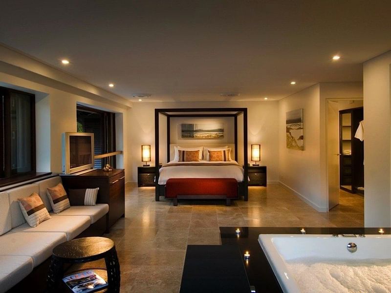 Bed and seating area with jacuzzi tub in Three-Bedroom Villas at Pullman Port Douglas