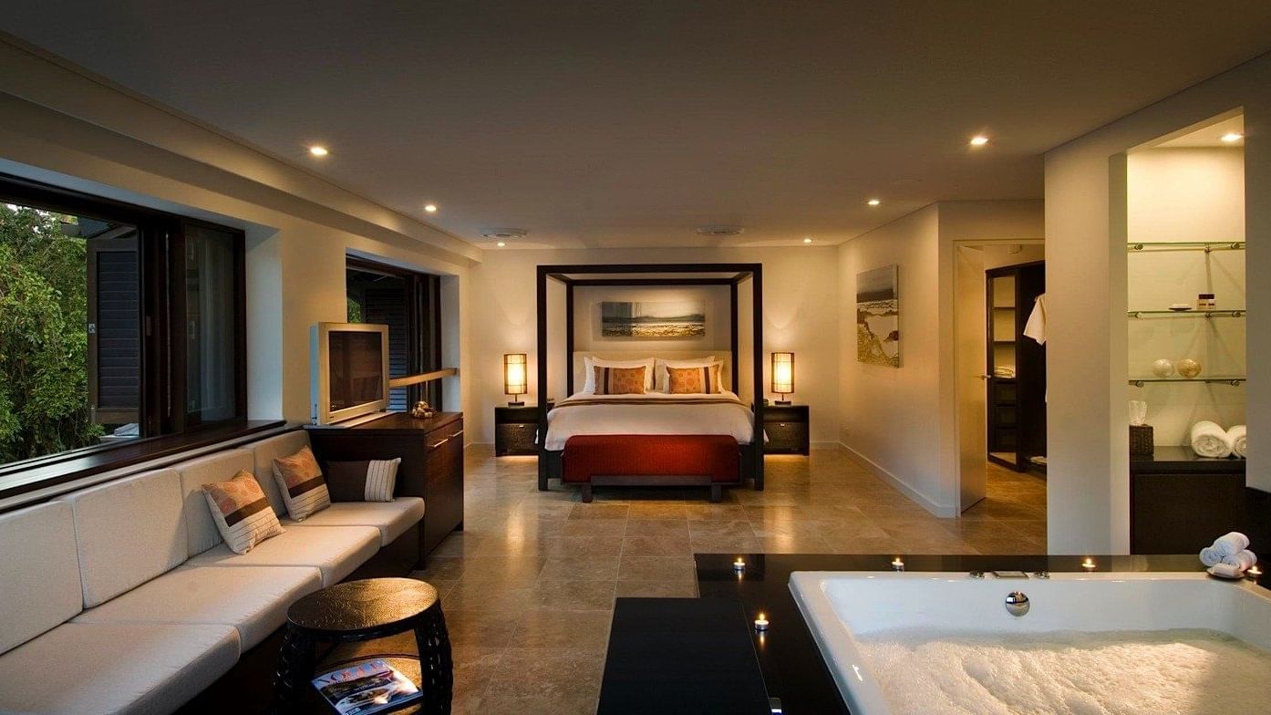 Bed and seating area with jacuzzi tub in Three-Bedroom Villas at Pullman Port Douglas
