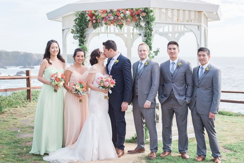 Newlyweds kissing near the coastline at Heritage House Resort