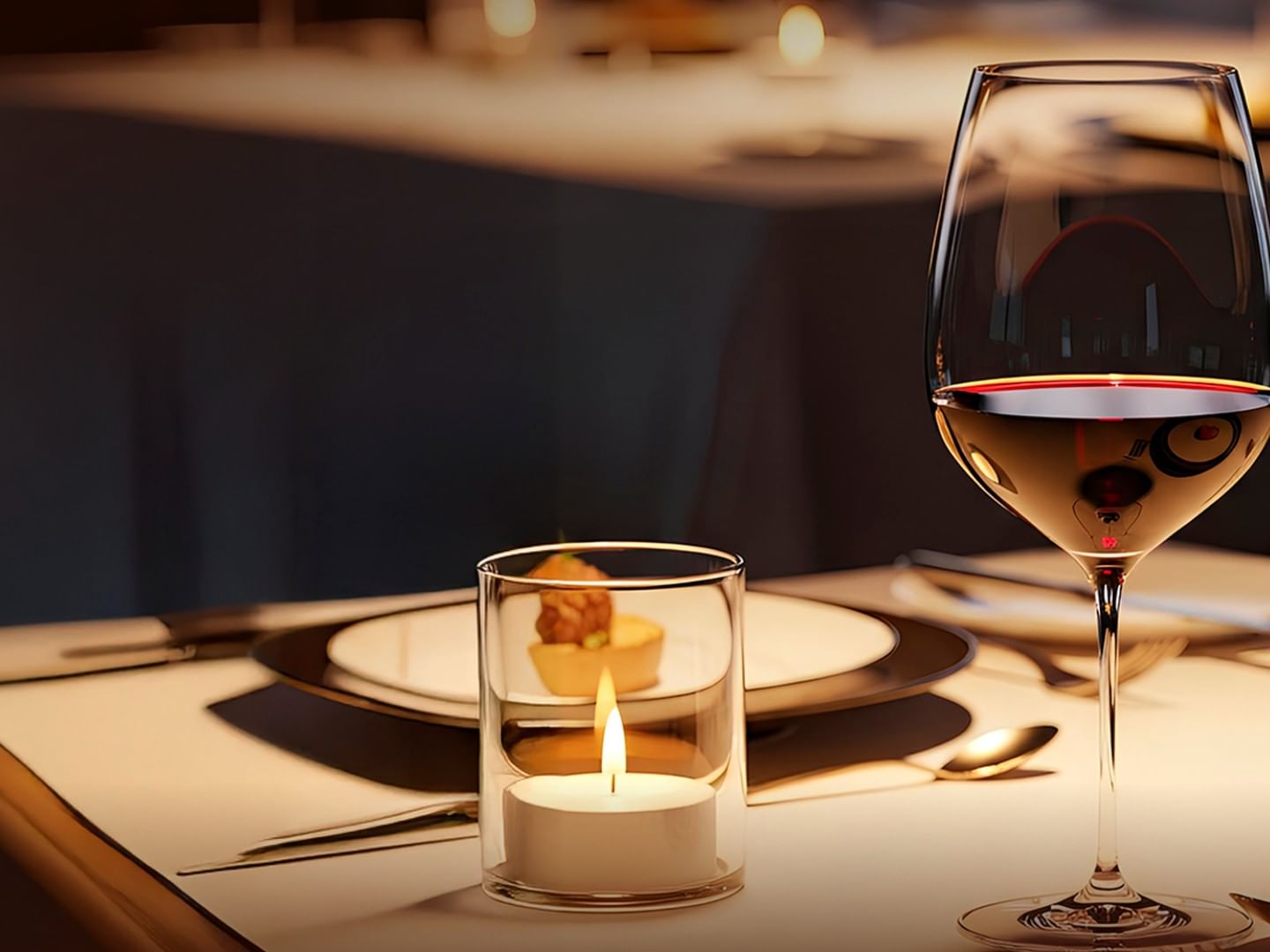 Wine glass and candle on an elegantly set table, conveying a romantic, cozy atmosphere at Camino Real