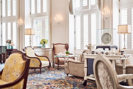 Park Lounge with tea cart, floral decor, and plush seating by bright windows at Park Hyatt Saigon