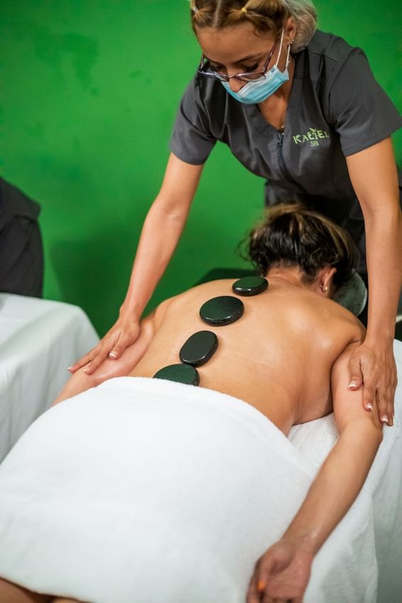 Lady receiving a hot stones therapy in the spa at Playa Blanca Beach Resort