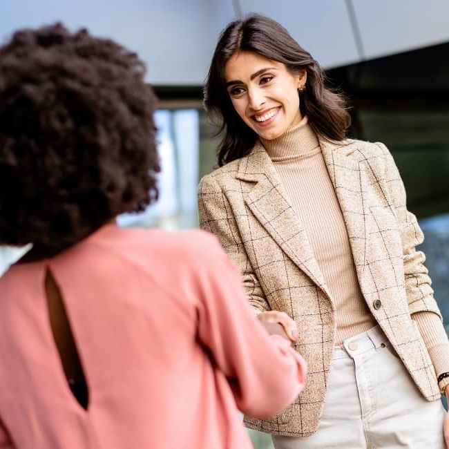 Women networking at conference featuring our article on 