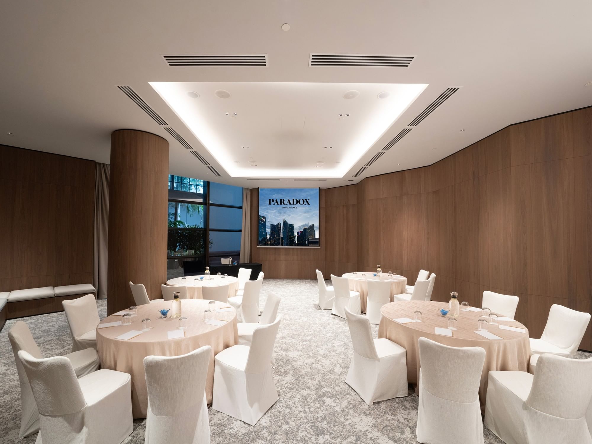 Cluster-style meeting room setup in the Sandalwood at Paradox Singapore, featuring neatly arranged tables, chairs, and professional conference amenities.