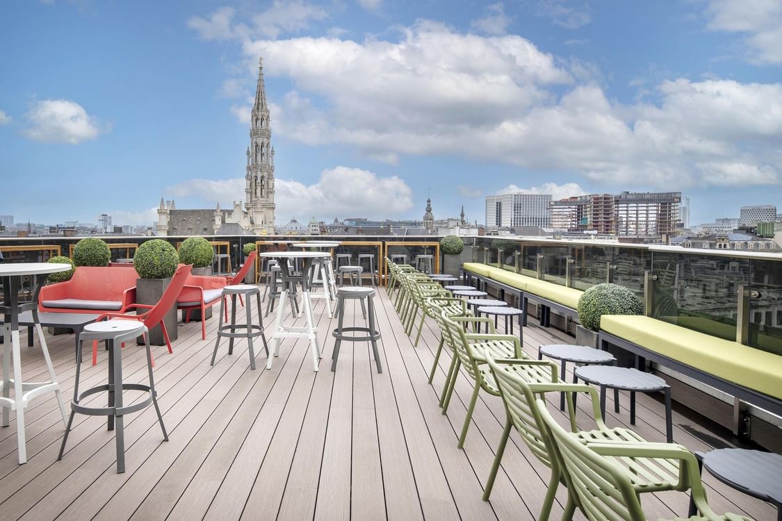 Outdoor rooftop seating area with modern furniture and city view at Warwick Brussels Bruxelles