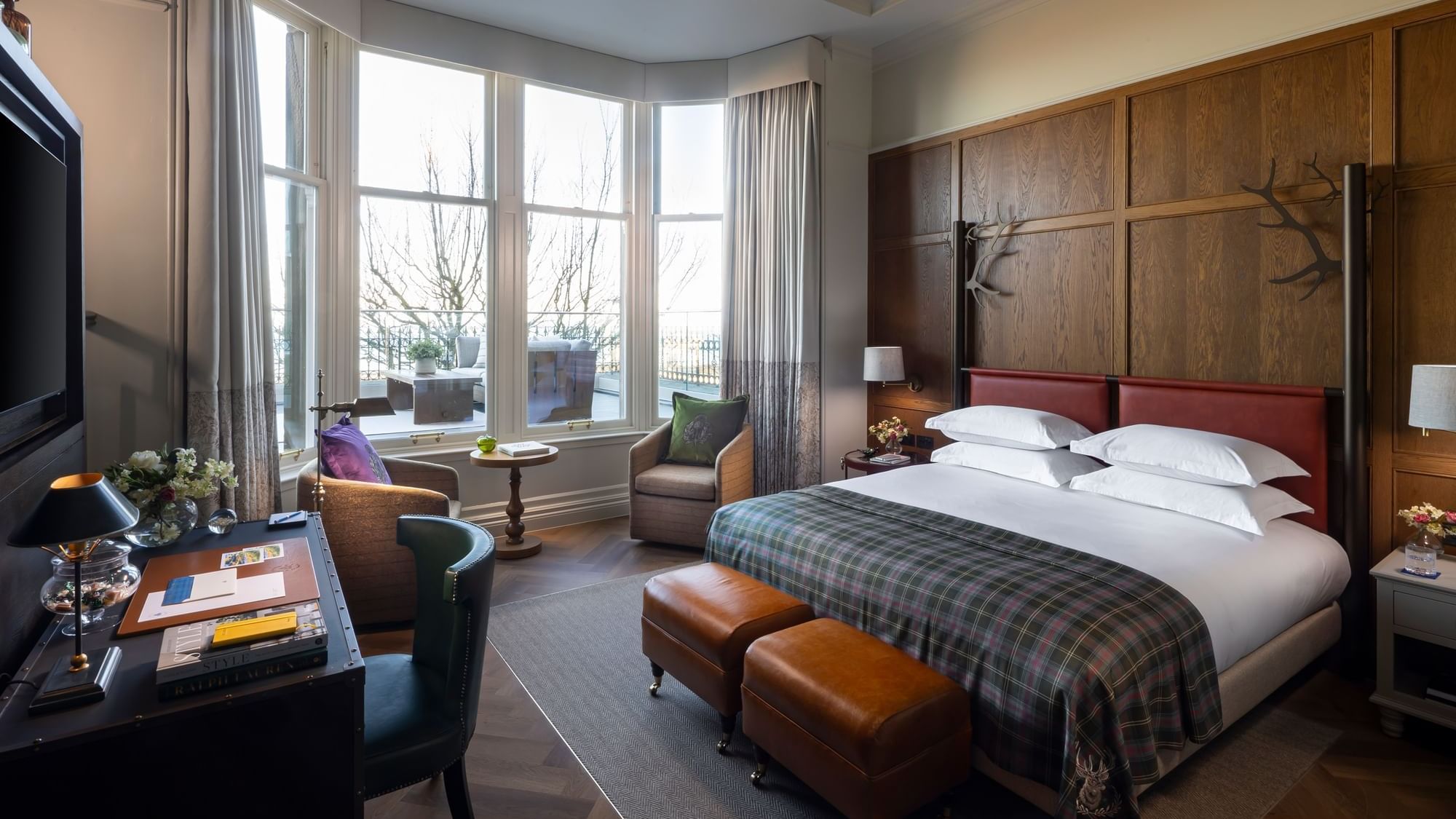 Work desk facing the bed with seating by the window in Suite with Sea View & Terrace at Seaton House