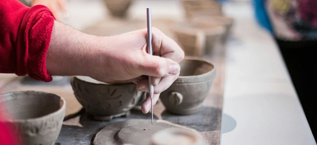 A group of coworkers making pottery as part of a team building activity in Canmore.