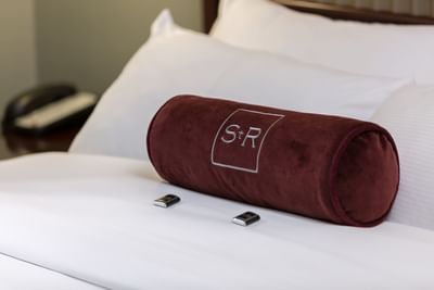 Close-up of branded bolster pillow on a cozy bed at The St. Regis Hotel, a boutique hotel Vancouver