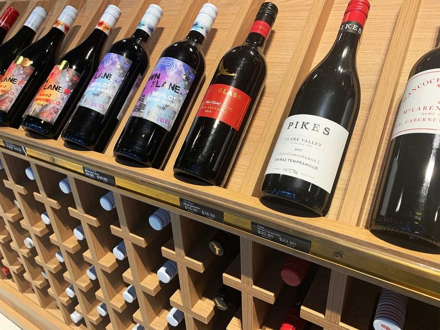 A wooden rack with various wine bottles at Encore by Mingara