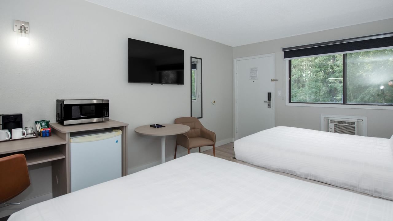 Guest room at Coast Red Deer Hotel with two queen beds and seating area