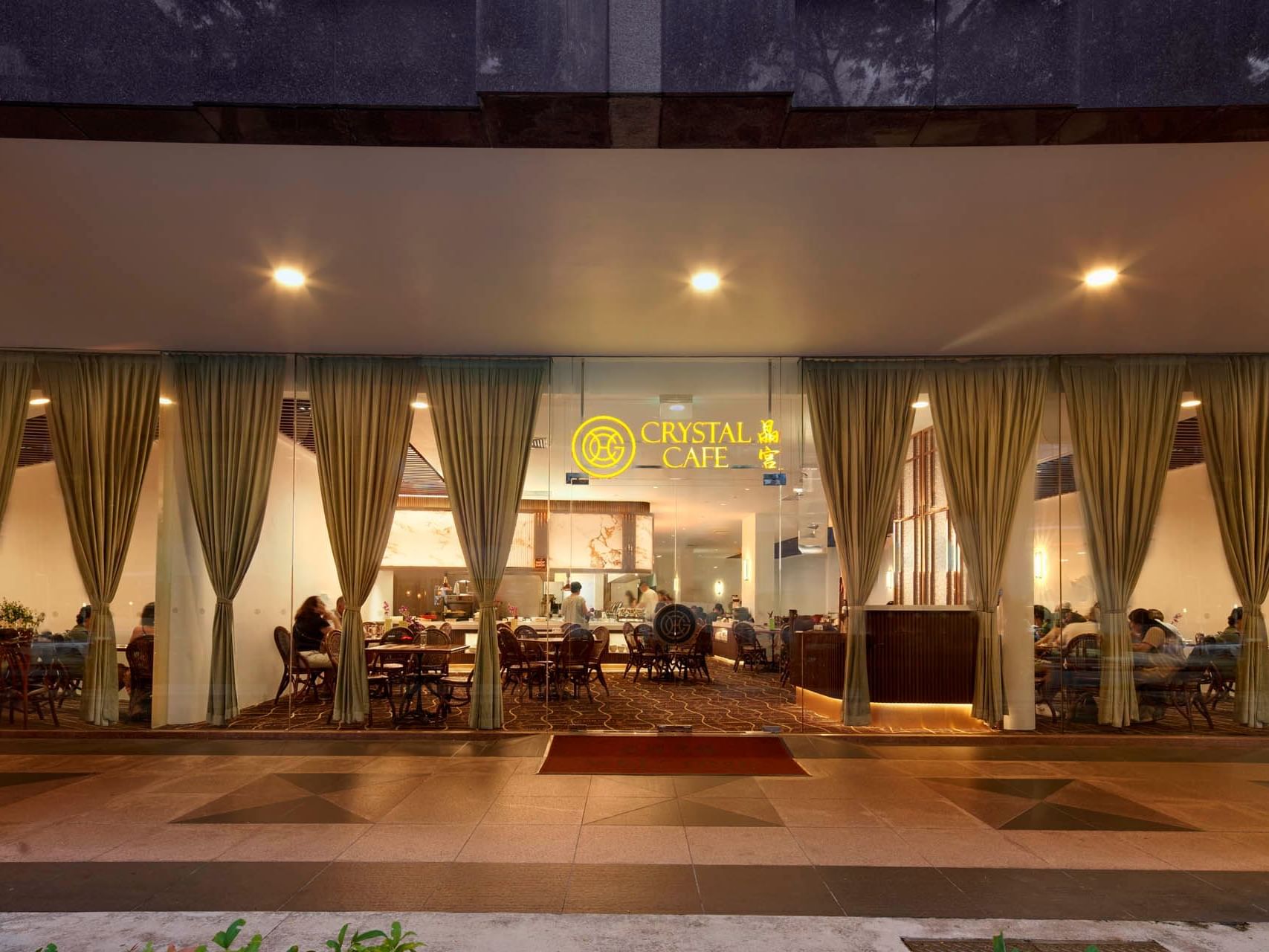 Exterior view of Crystal Cafe, showcasing glass windows, elegant curtains, and diners enjoying meals at Orchard Grand Court