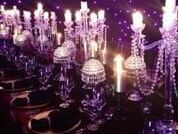 Formal dinner table setting with crystal candelabras, a tablecloth, and deep purple ambient lighting at The Sebel Brisbane