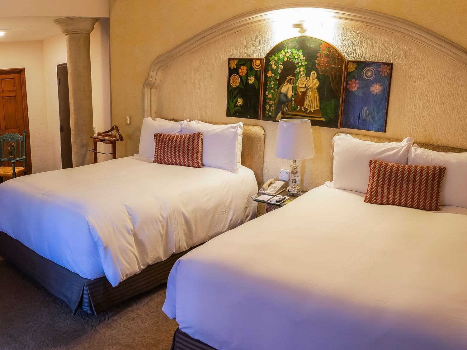 Grand Class room with two double beds, decorative artwork, and arched alcove at Quinta Real Zacatecas