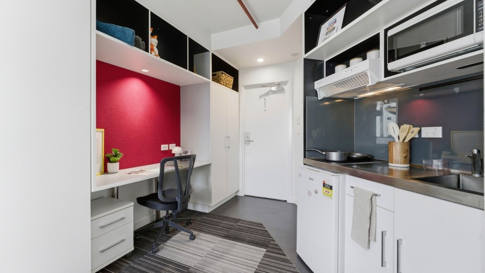 White kitchen with desk and chair at UniLodge Auckland City.