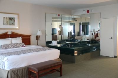 Executive Jacuzzi Suite with plush king bed and in-room jetted whirlpool tub surrounded by mirrors at Clayton Plaza Hotel