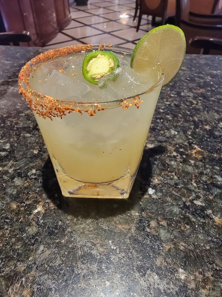 Chilled cocktail with a spicy rim, garnished with a slice of lime and jalapeno at The Rose Hotel