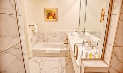 Marbled bathroom vanity & bathtub area at Trianon Bonita Bay