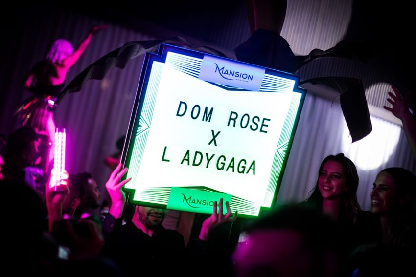 Crowd at a party with illuminated sign for Dom Rose X L AdyGaga at Paradox Vancouver