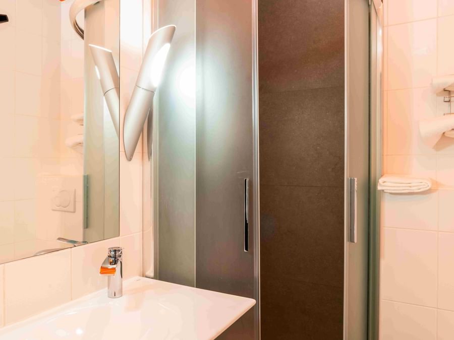 Salle de bains moderne avec douche et lavabo de la chambre simple à Hôtel de la Paix, Brest.