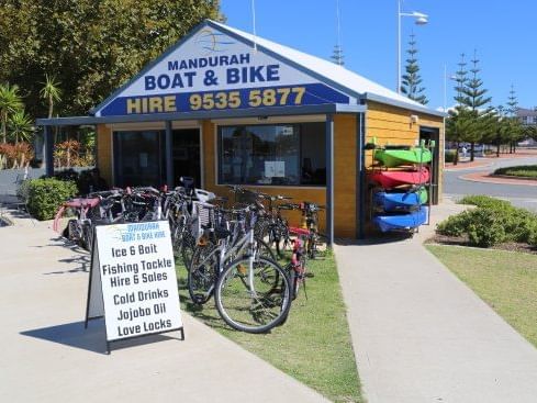 Small shop for Mandurah Boat & Bike Hire with bikes displayed outside on a sunny day near The Sebel Mandurah