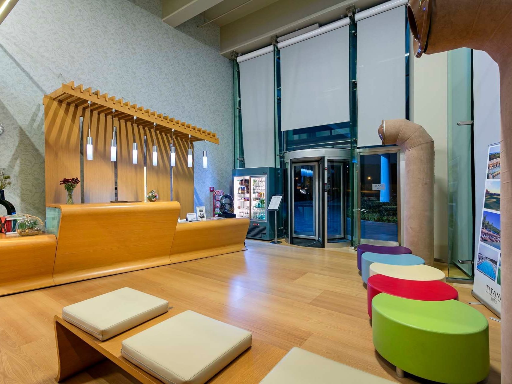 Modern lobby with wooden reception desk & colorful seating at Titanic Anadolu Gebze