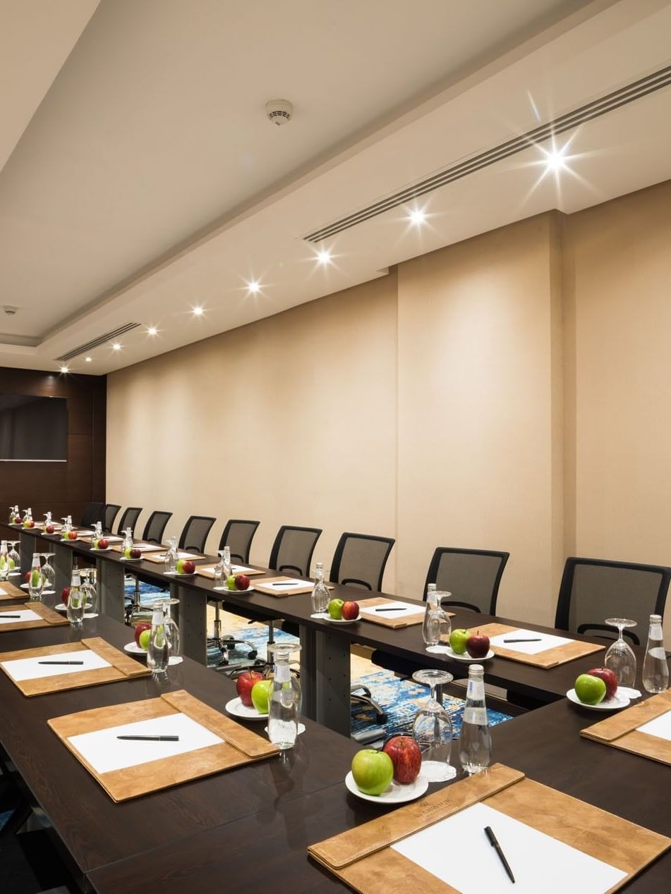 U-shaped table setup facing hanging TV in Khalej Meeting Room at Naviti by Warwick Dammam