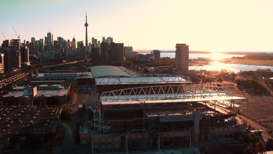 Aerial view of BMO Field\'s stadium roof by the waterfront, near the skyline at sunset at Hotel X Toronto