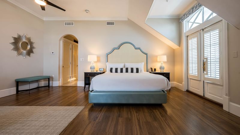 A spacious guest suite with hardwood floors and a king bed at The Pearl Hotel.