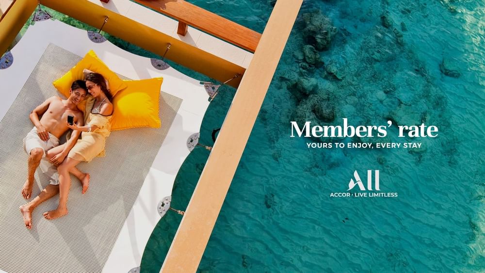 Poster of Members' Rate featuring a happy couple relaxing on a hammock net over the sea at Novotel Sydney Olympic Park
