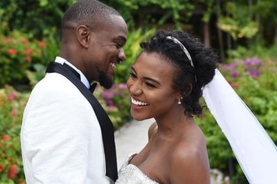 Smiling bride and groom pose together outdoors at Bougainvillea Barbados