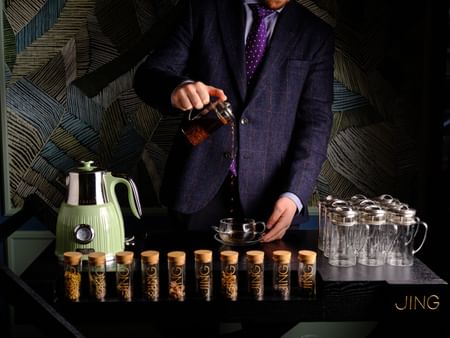 Barista pouring expresso by the counter at The Capital Hotel London