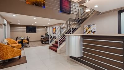 a hotel front desk next to a stair case