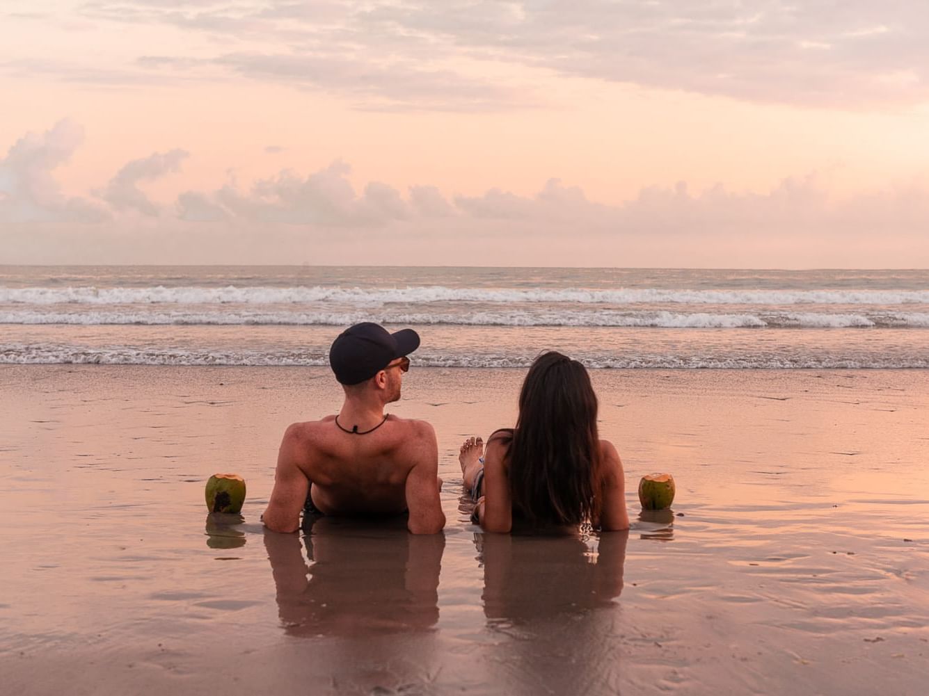 Couple sitting on the shore and enjoying the sunset near Los Altos Resort