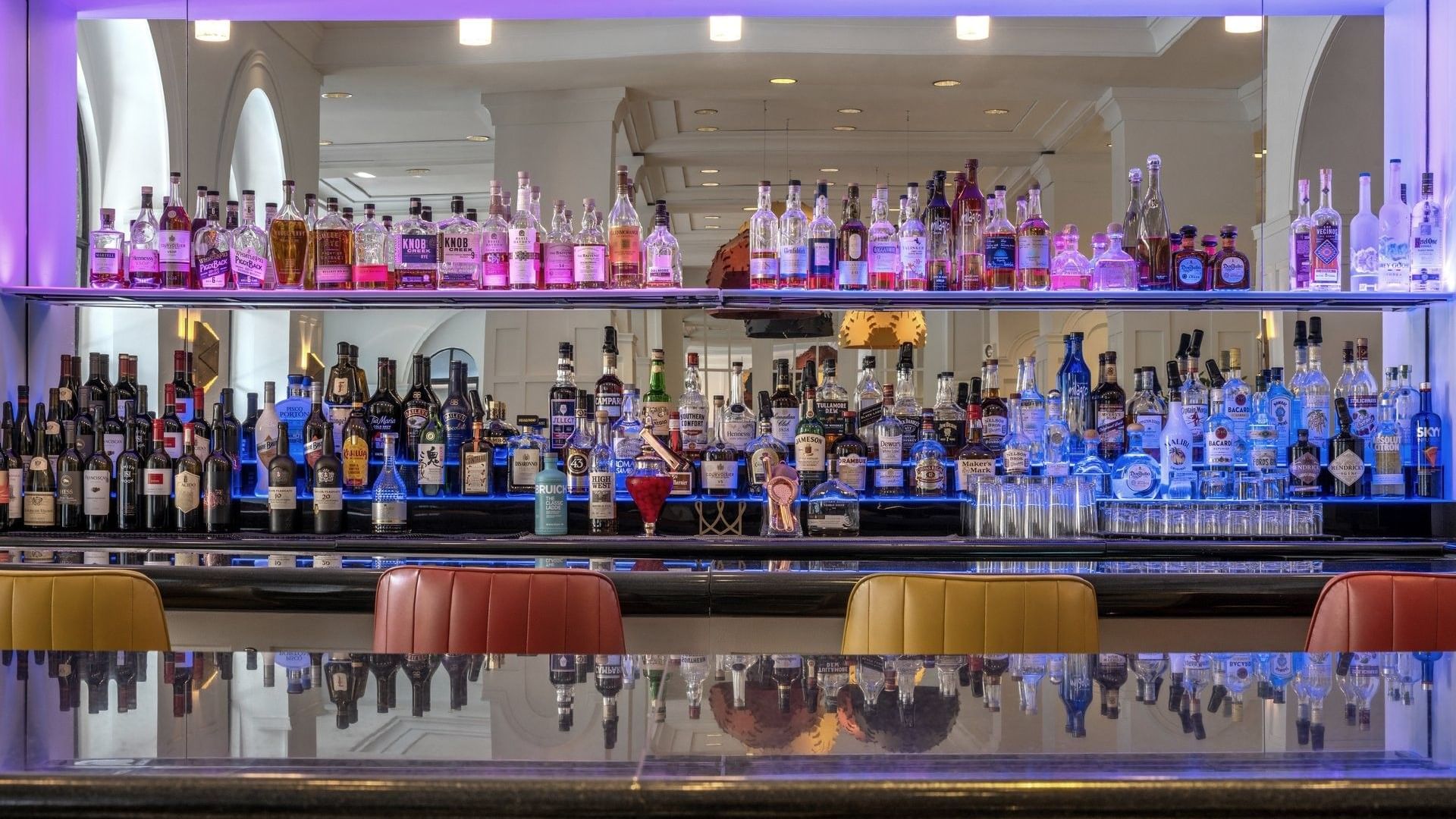 Well-stocked bar with colorful bottles and modern decor in Allerton Hotel Lobby Lounge at Warwick Allerton Chicago