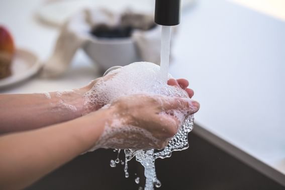 Close-up of a person washing hands at Kopster Hotel Colombes