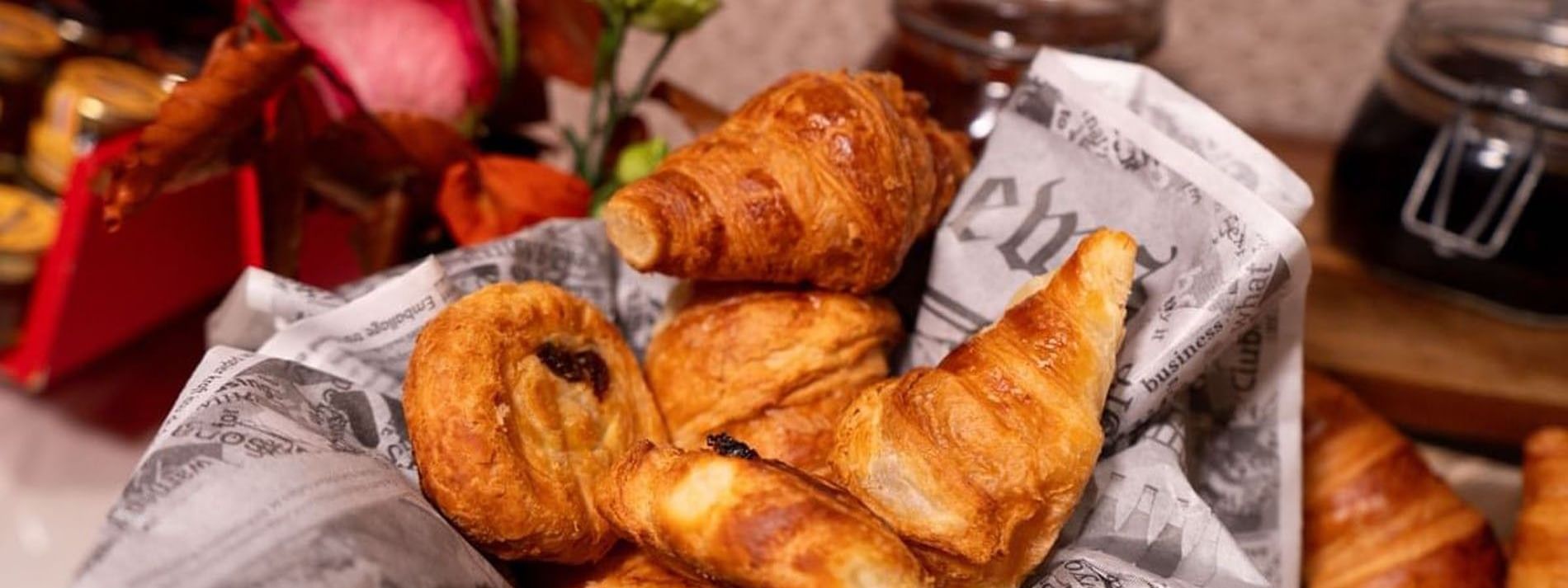 Flaky croissants and danishes in a basket lined with in Breakfast & 24-Hour Room Service at Warwick Paris Champs Elysées