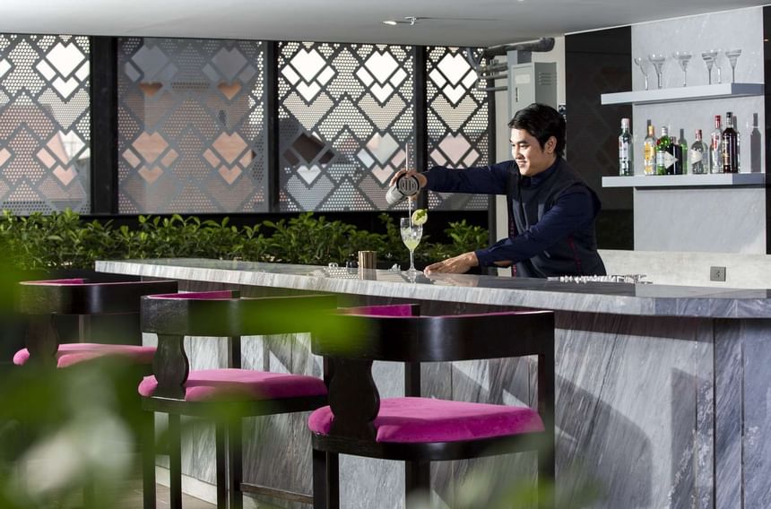 Bartender pouring drinks to glass at U Hotels & Resorts