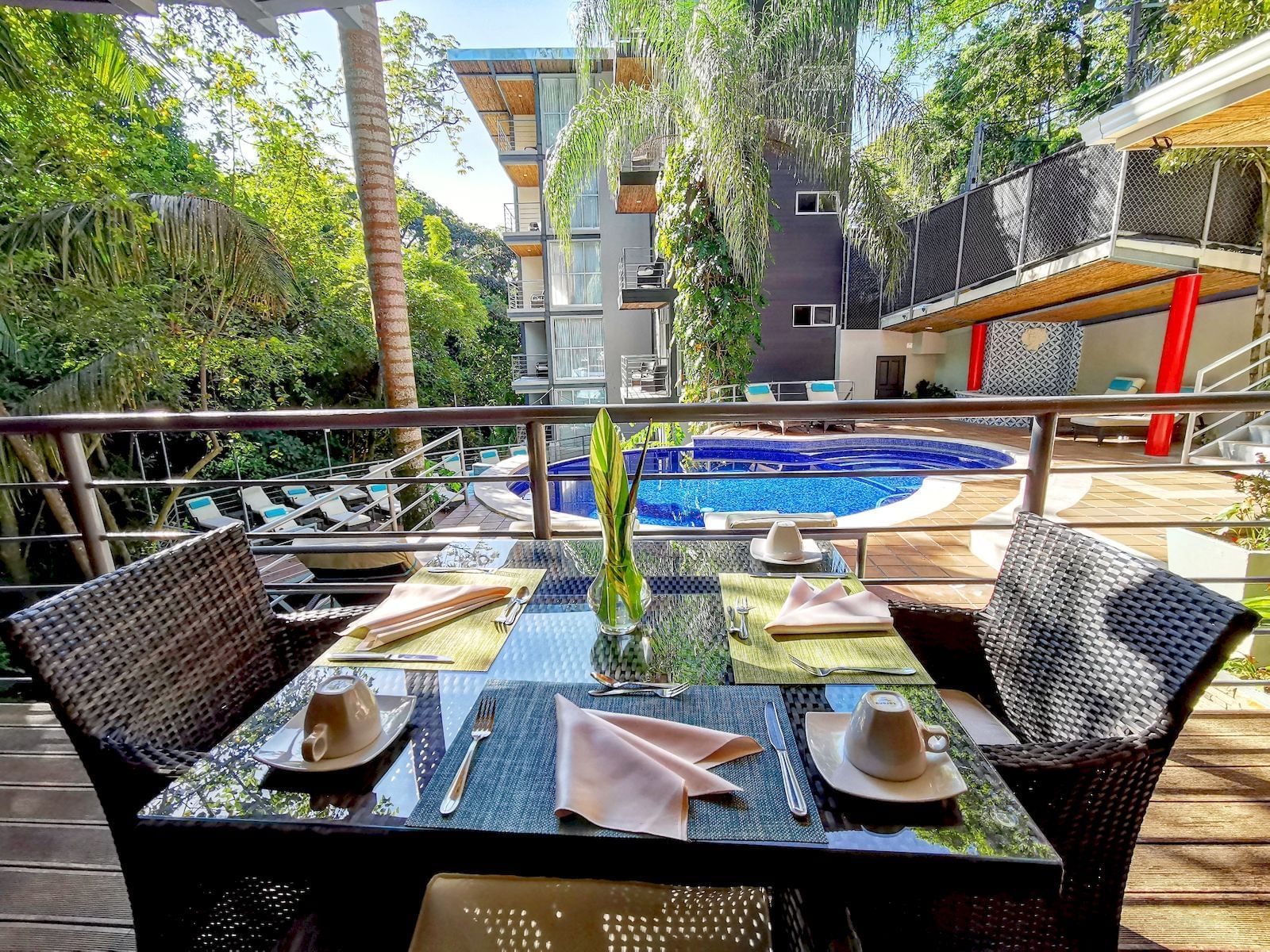 Mesa de comedor al aire libre con vista a la piscina en Sloth Restaurant en Los Altos Resort