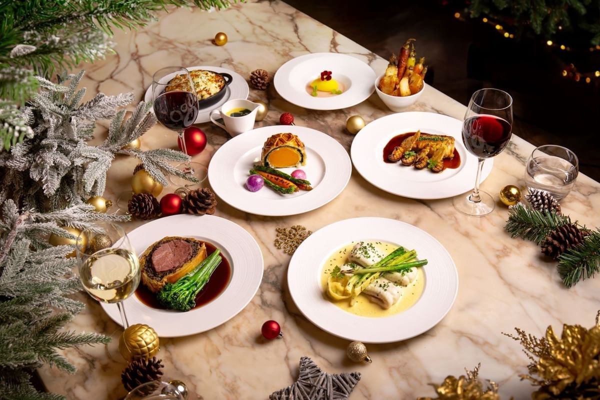 Festive buffet spread featuring various dishes, wine, and Christmas decorations at The May Fair Hotel