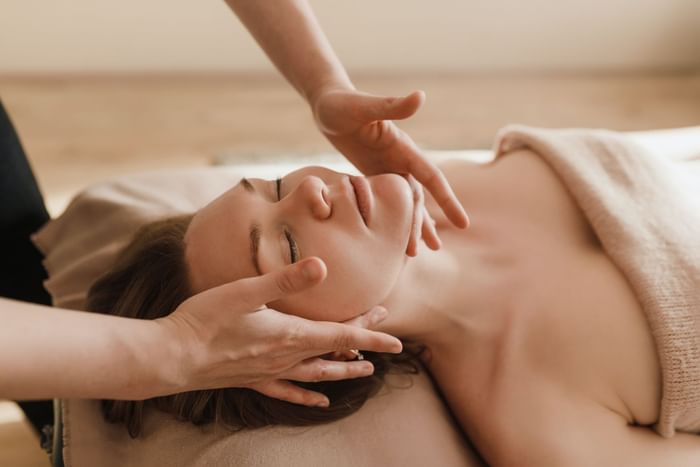 Therapist giving a relaxing facial massage to a guest on a comfortable table at Oregon Garden Resort