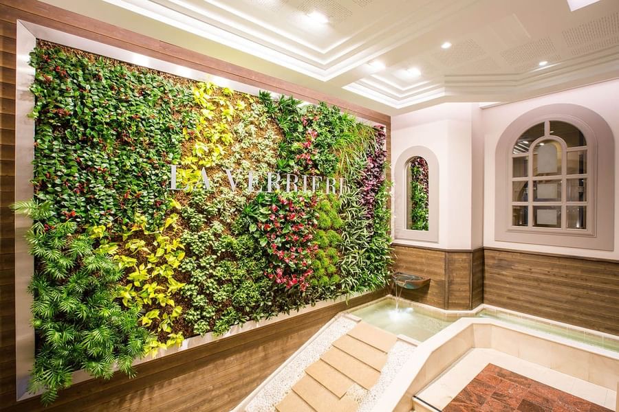Restaurant La Verrière features lush green living wall and a small peaceful water fountain at Le Grand Hôtel des Thermes