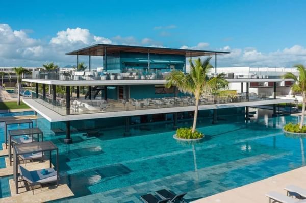 Exterior view of the beach club surrounded by a pool at Live Aqua Punta Cana