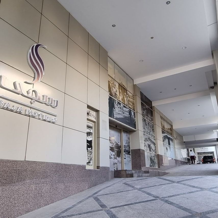 Enseigne extérieure argentée pour Saja Hotels, installée sur la façade moderne en carrelage gris du Saja by Warwick Makkah