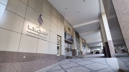Exterior silver signage for Saja Hotels mounted on a modern grey tiled building facade at Saja by Warwick Makkah