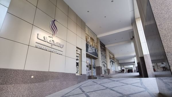 Enseigne extérieure argentée pour Saja Hotels, installée sur la façade moderne en carrelage gris du Saja by Warwick Makkah